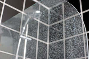 The outside of a glass shower with hard water