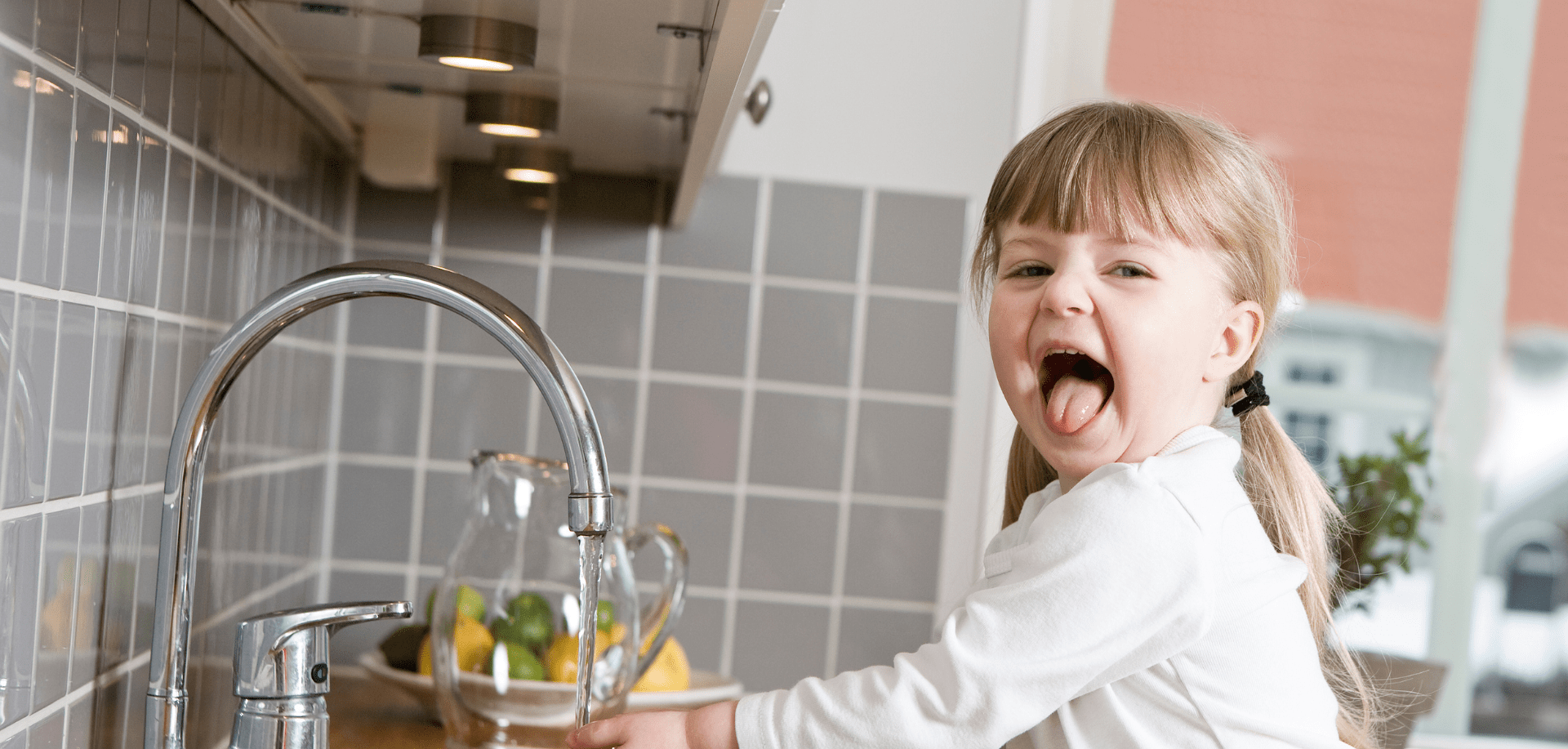 A girl drinking softened water from a tap